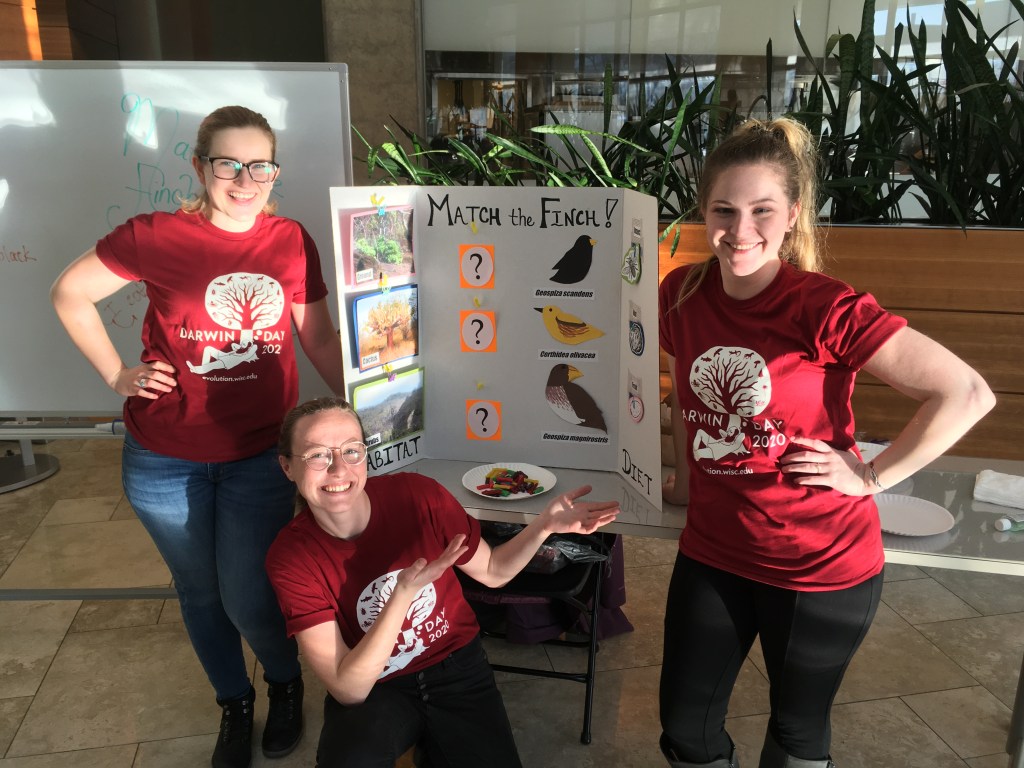 Katie and several public philosophers at UW pose by their Darwin Day board.